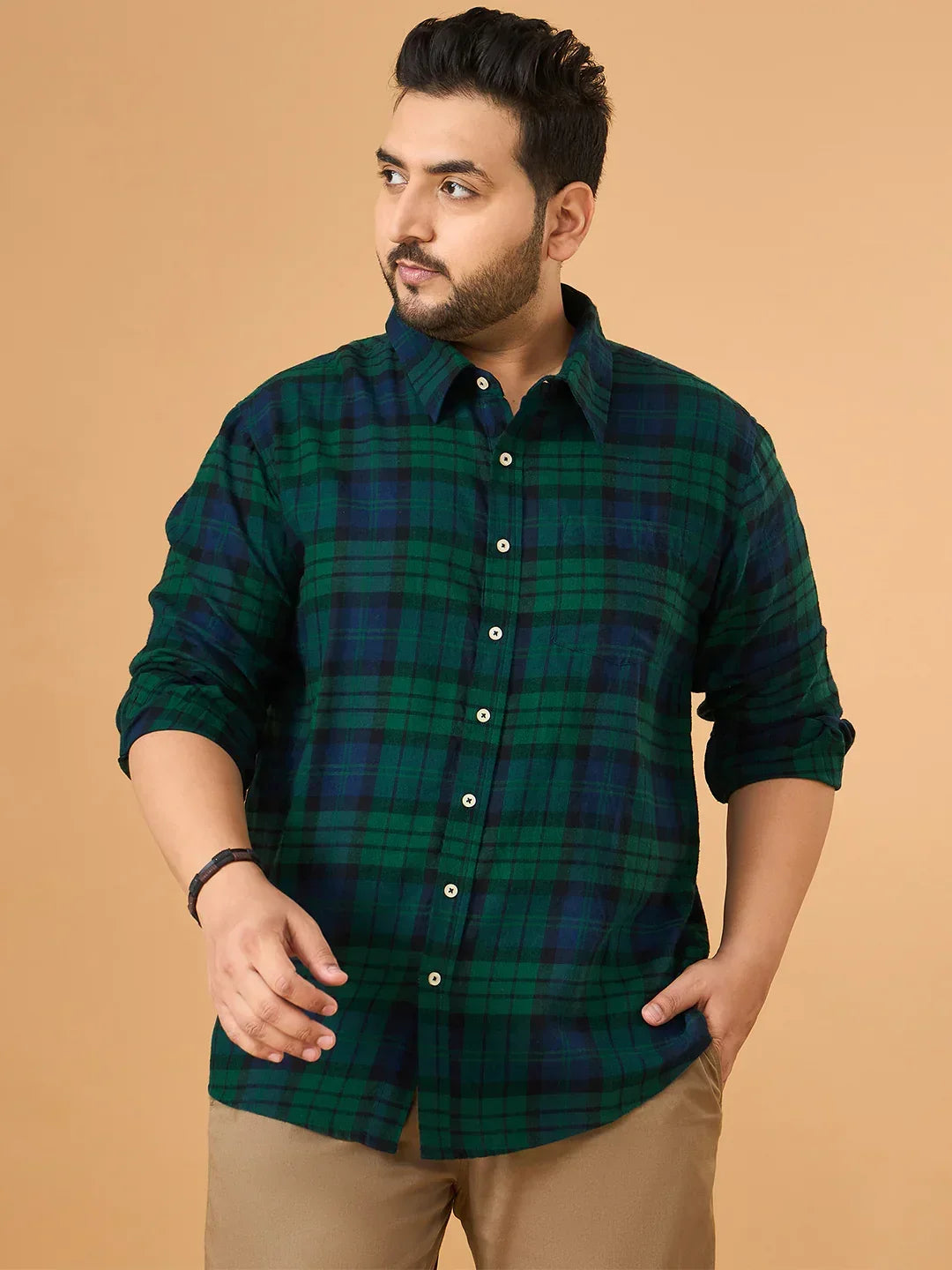 Plus size man wearing green blue checkered casual shirt and beige pants