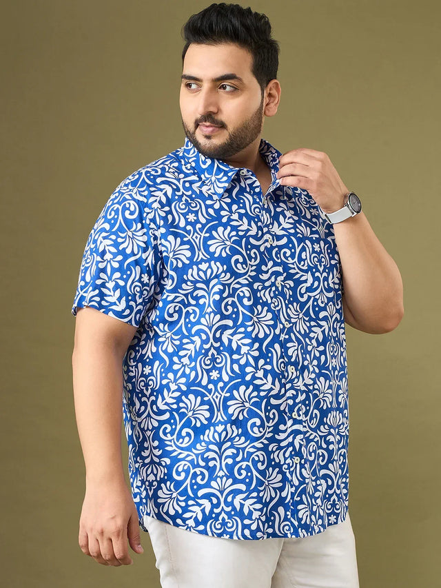 Plus size man in blue and white floral print casual shirt and white pants