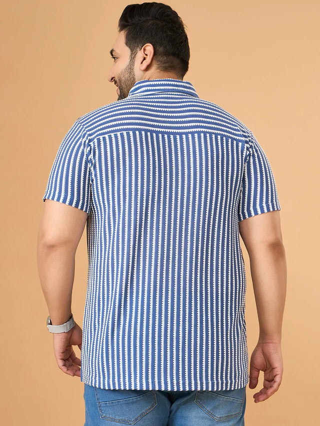Plus size man wearing blue and white vertical striped short sleeve shirt and blue jeans