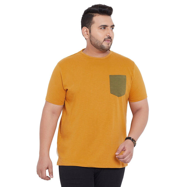 Plus size man wearing mustard yellow t-shirt with green pocket, short sleeves, casual style