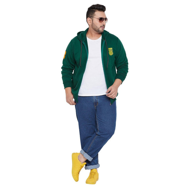 Plus size man in green hoodie, white t-shirt, blue jeans, and yellow sneakers
