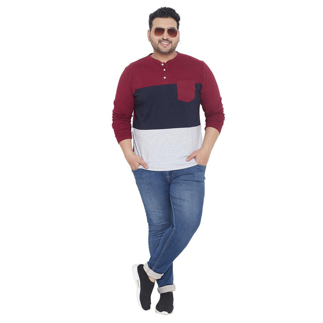 Plus size man wearing colorblock henley t-shirt, blue jeans and sunglasses, posing casually