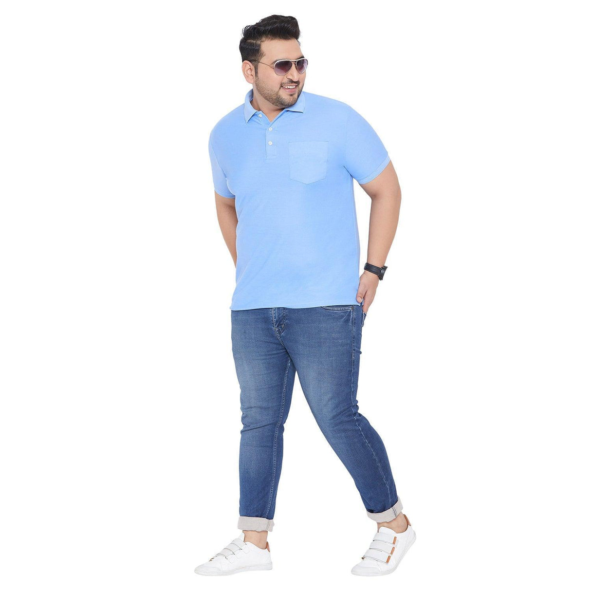 Plus size man wearing light blue polo shirt, blue jeans, and white sneakers on white background