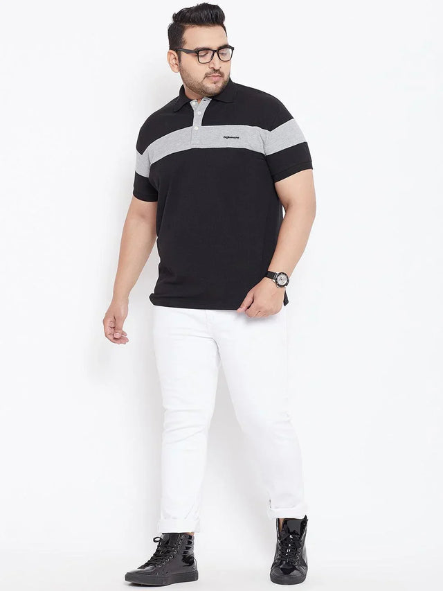 Plus size man in black and grey polo shirt, white jeans, black sneakers on white background
