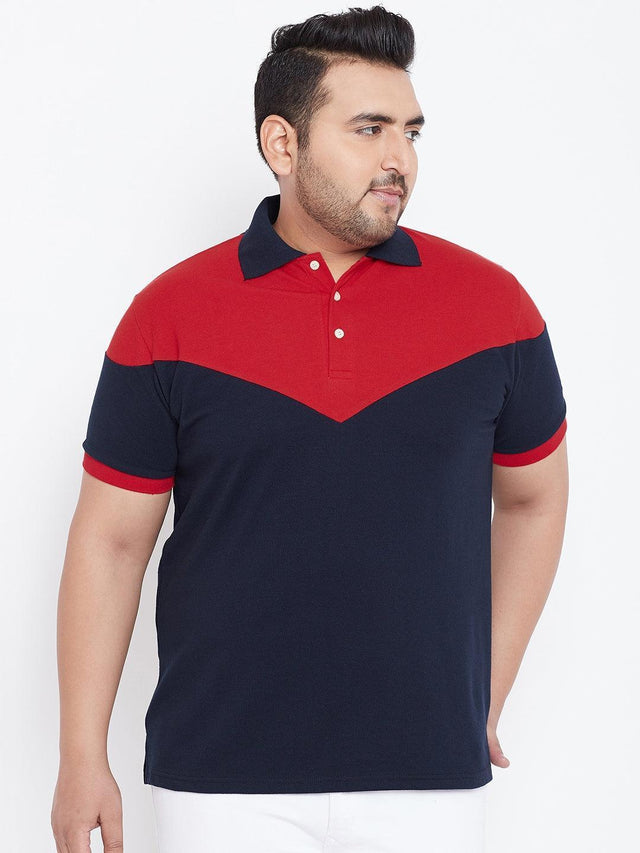 Plus size man wearing a navy and red colorblock polo t-shirt, white pants, front view