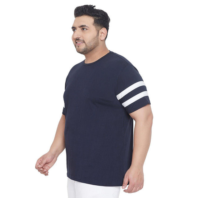 Plus size man wearing navy blue t-shirt with white sleeve stripes, side view