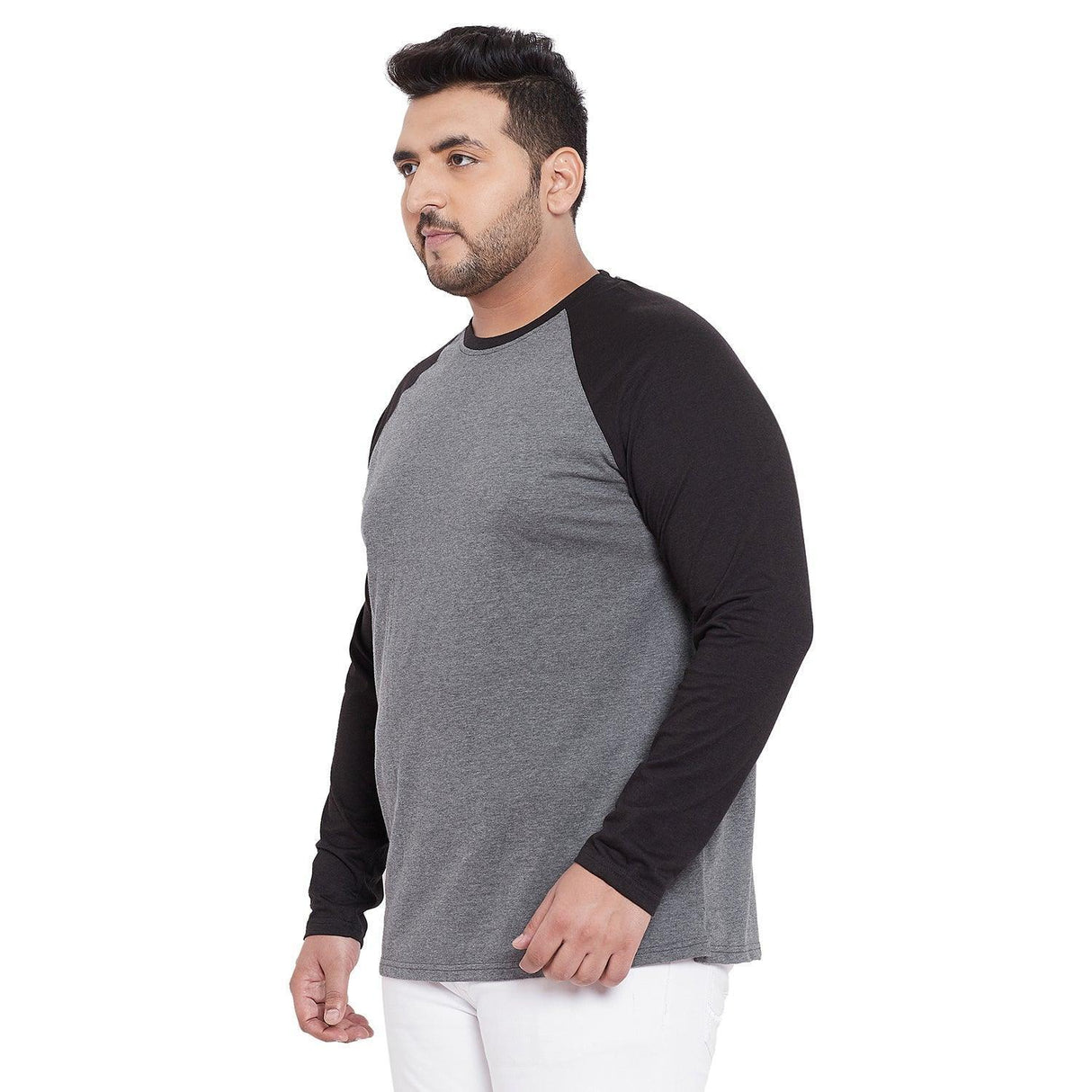 Plus size man wearing grey and black long sleeve raglan t-shirt with white pants