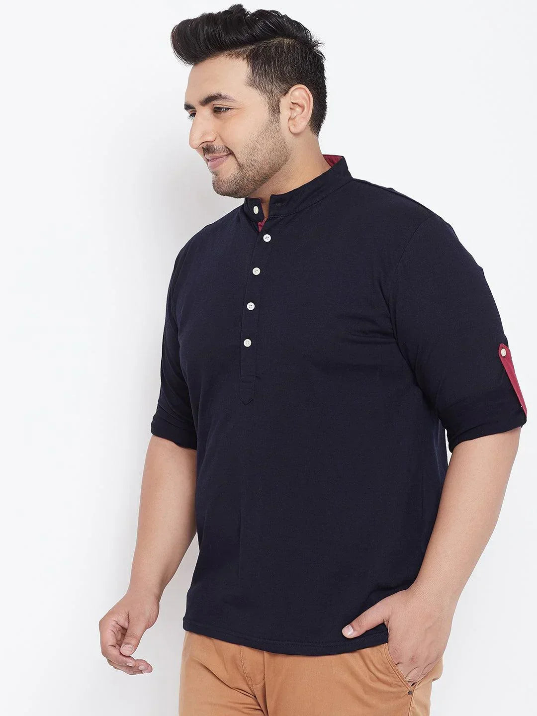 Plus size man in navy mandarin collar shirt with rolled-up sleeves and beige pants
