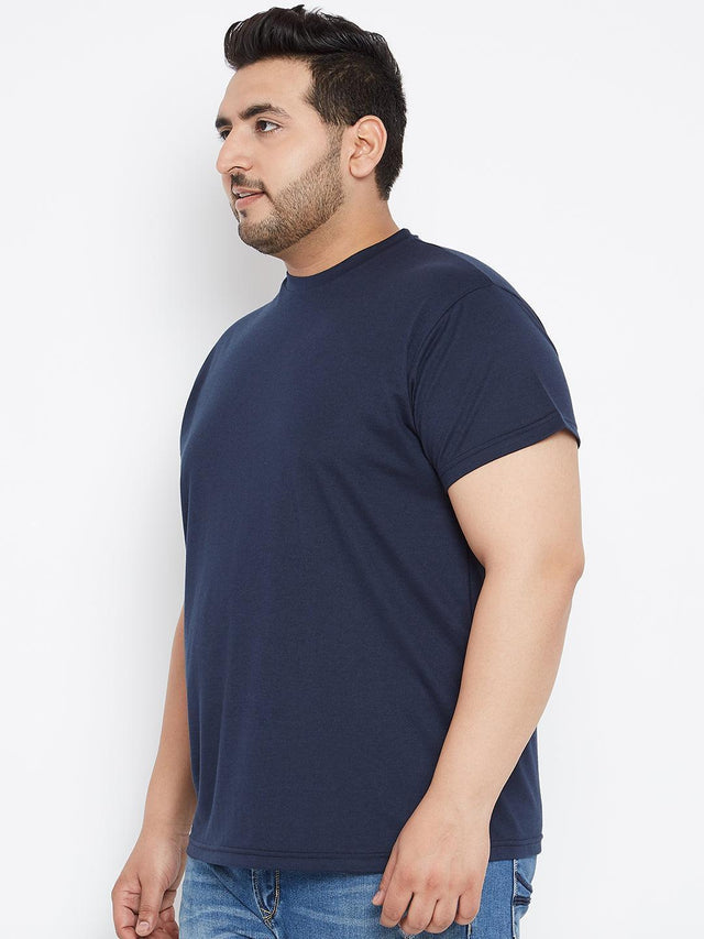 Plus size man in navy blue crew neck t-shirt and blue jeans, side view, white background