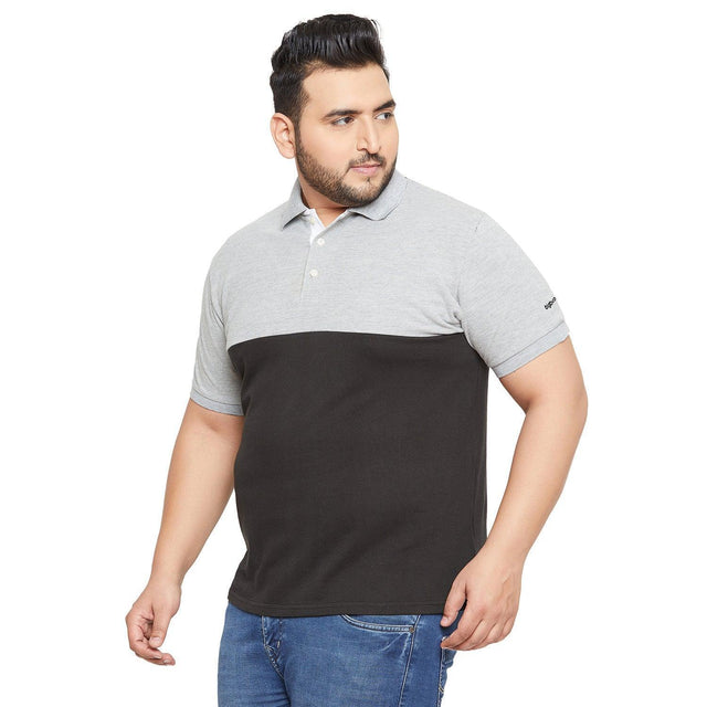 Plus size man in short sleeve grey and black polo shirt and blue jeans on white background