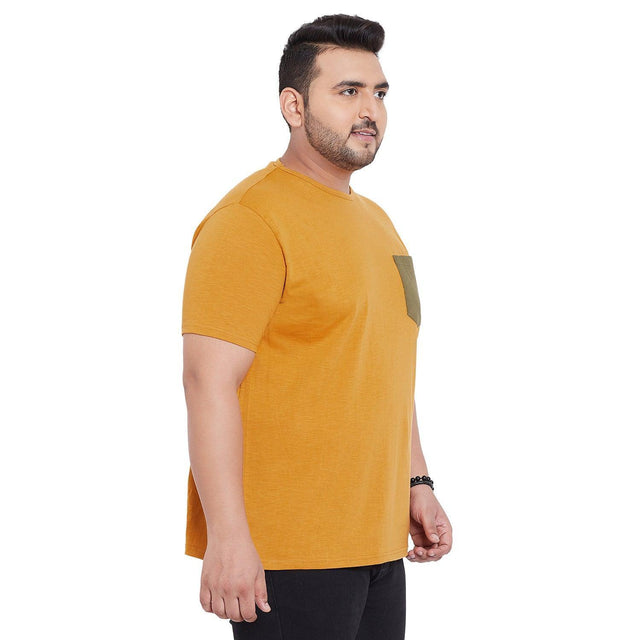 Plus size man wearing mustard yellow short sleeve t-shirt with contrasting chest pocket
