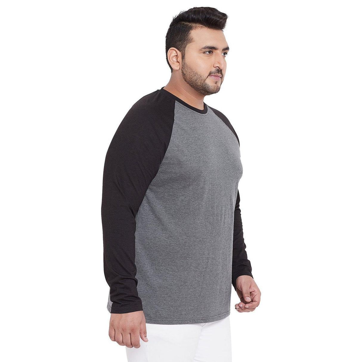 Plus size man in grey and black raglan long sleeve t-shirt and white pants side view