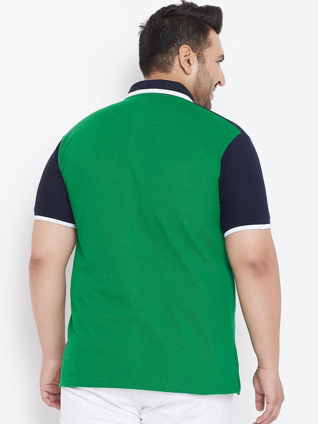 Back view of a man wearing a green and navy short sleeve polo shirt and white pants
