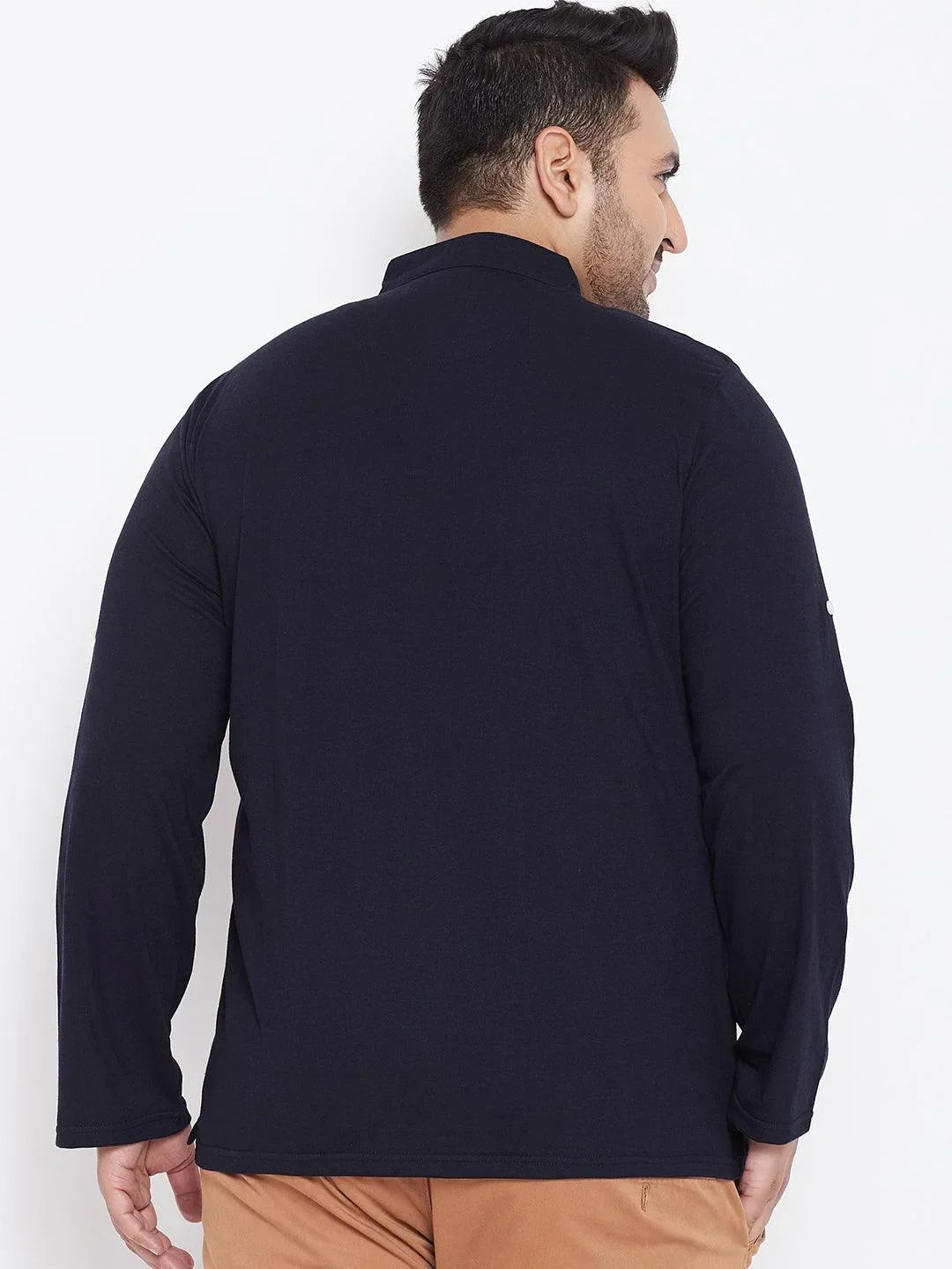 Back view of man in plus size navy blue long sleeve shirt and brown pants