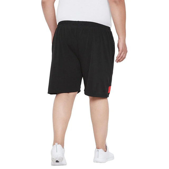 Back view of a man in plus size black shorts and white sneakers for men