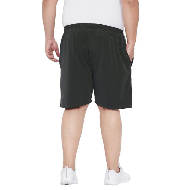 Back view of plus size man wearing black shorts and white sneakers on white background