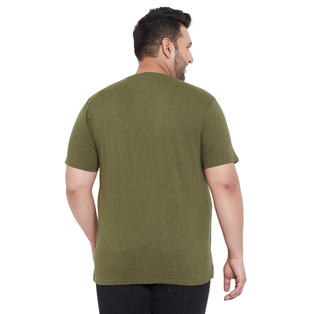 Back view of a plus size man wearing an olive green short sleeve t-shirt and black jeans