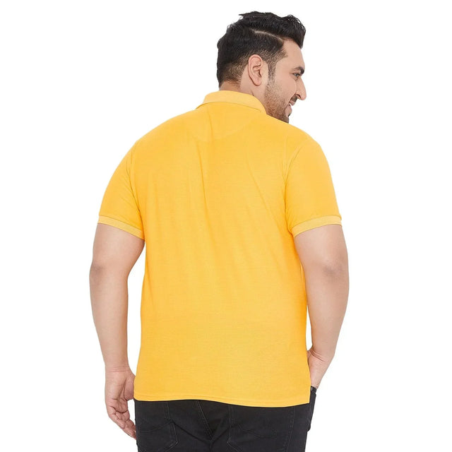 Back view of a man wearing a yellow plus size short sleeve polo shirt and black jeans