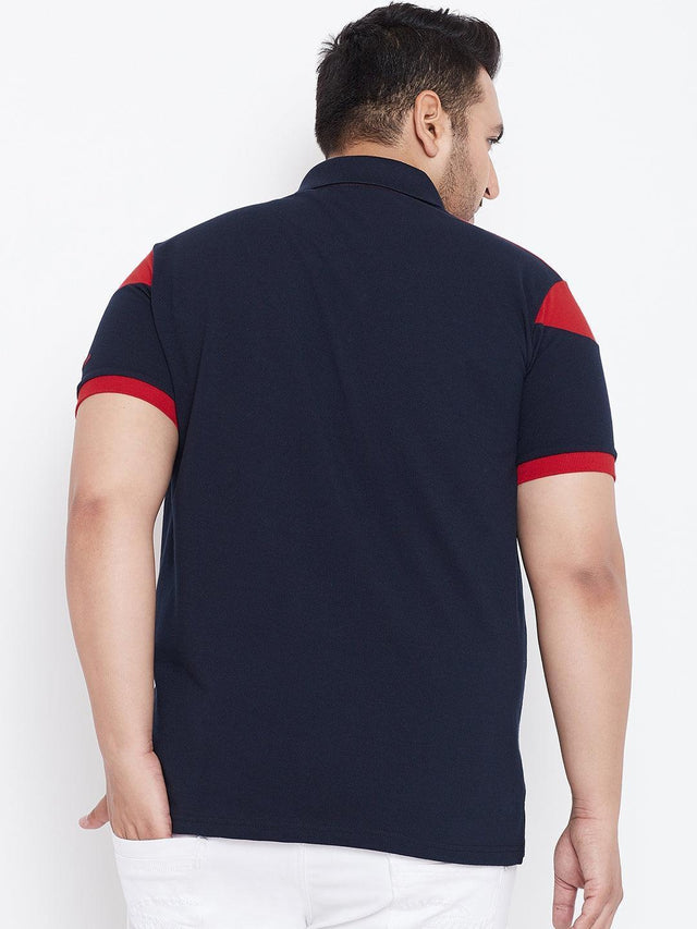Back view of a plus size man wearing a navy polo shirt with red sleeve accents
