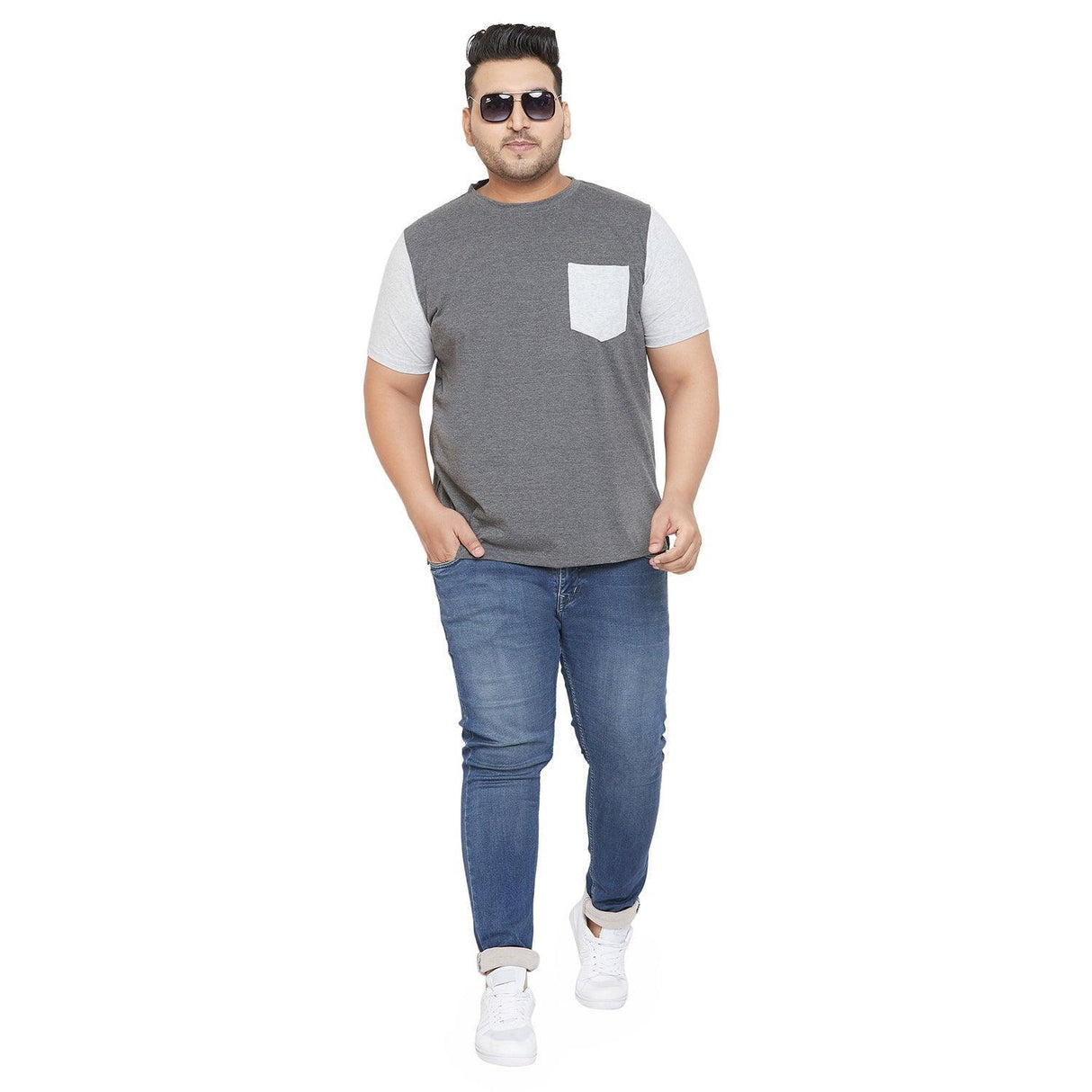 Plus size man in grey and white short sleeve t-shirt, blue jeans, and white sneakers