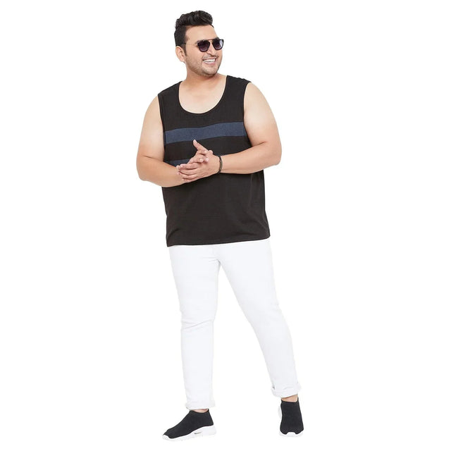 Plus size man wearing black sleeveless t-shirt, white jeans, and sunglasses on white background