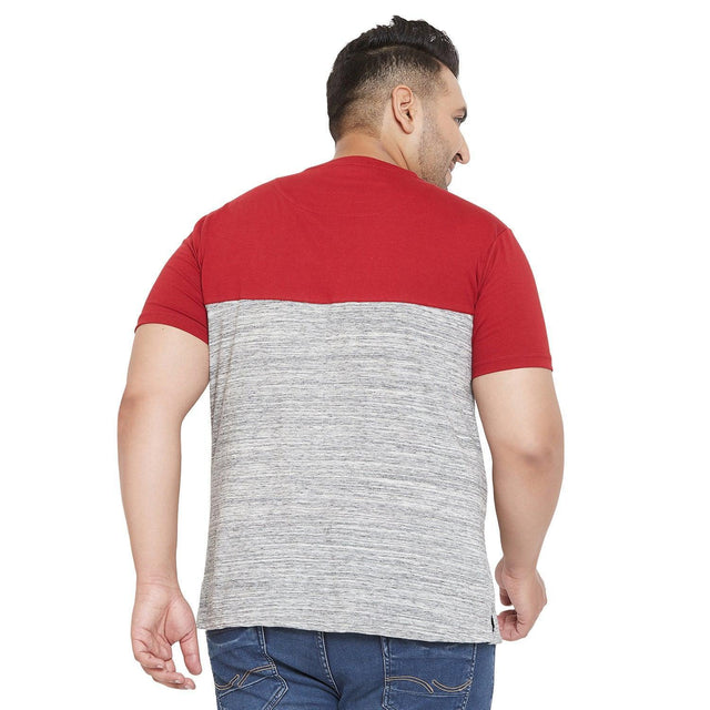 Plus size man wearing a red and gray colorblock t-shirt and blue jeans, viewed from the back