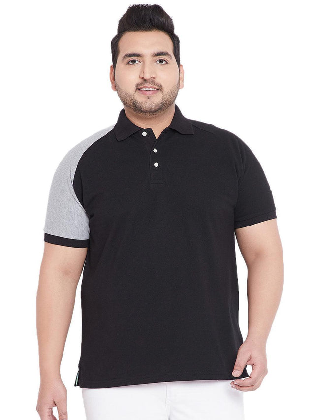 Plus size man wearing black polo t-shirt with grey sleeve, white background