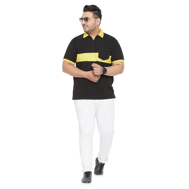 Plus size man in a black and yellow polo t-shirt with white jeans and navy sneakers