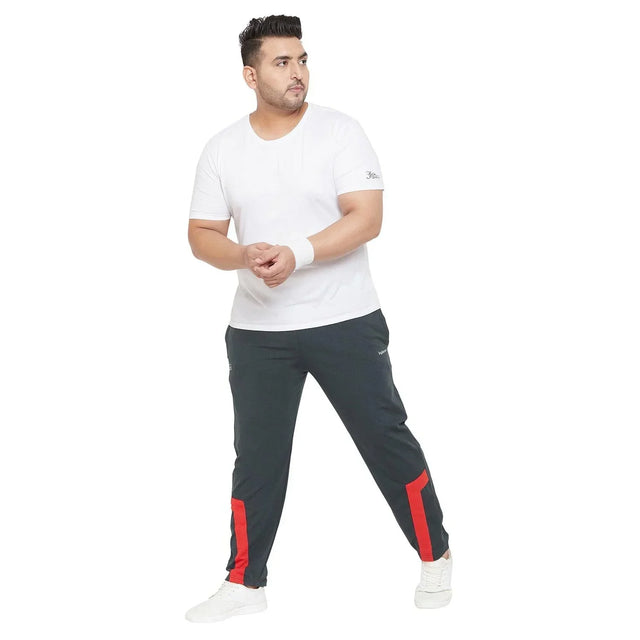 Plus size man in white t-shirt and black joggers with red stripes, casual pose, white sneakers
