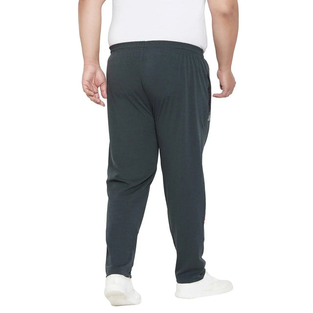 Back view of a man in plus size dark jogger pants and white sneakers, isolated on white background.