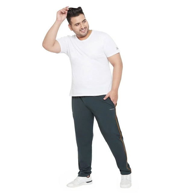 Plus size man in white t-shirt and dark joggers with yellow stripe, posing casually
