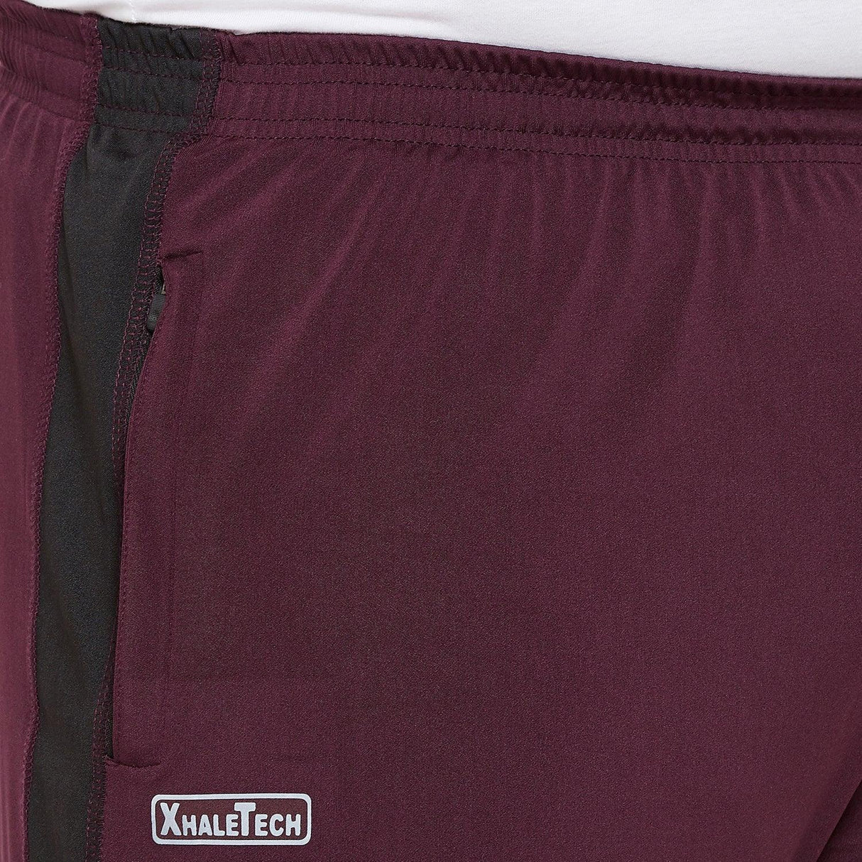 Close-up of maroon plus size men's joggers with elastic waistband and black side stripe