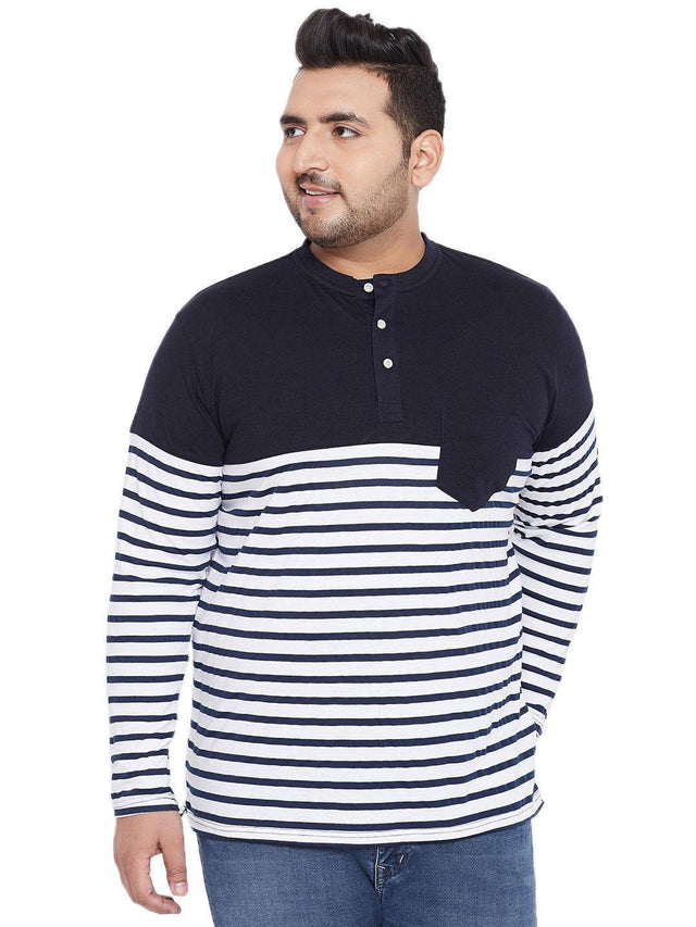 Plus size man wearing navy and white striped long sleeve henley t-shirt with jeans