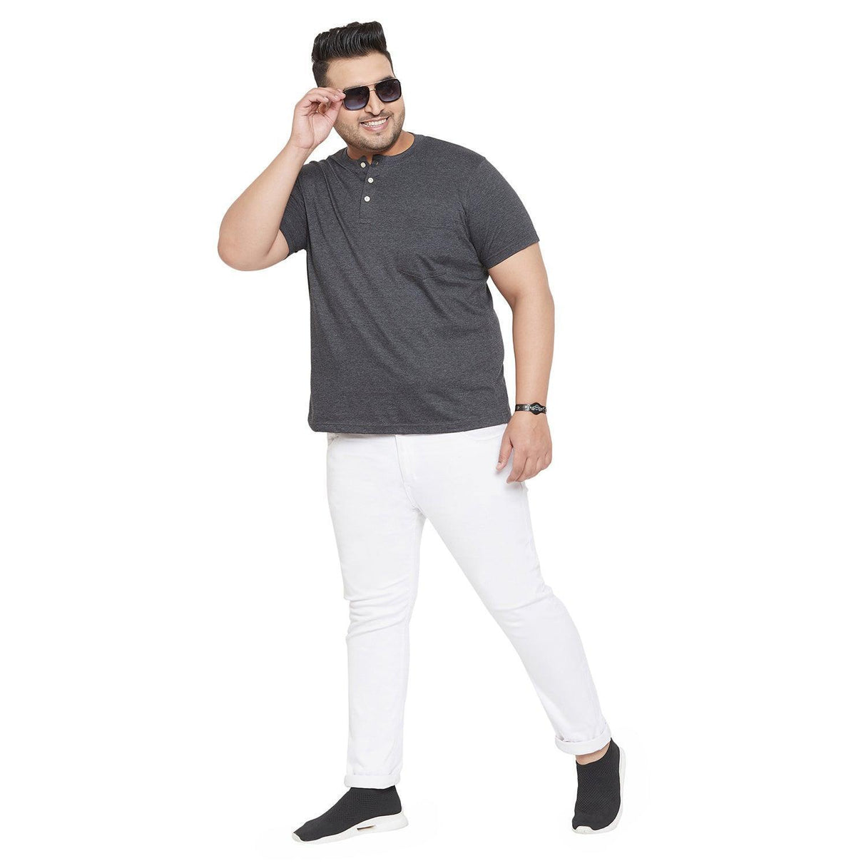 Plus size man in grey short sleeve henley t-shirt and white jeans, posing confidently.
