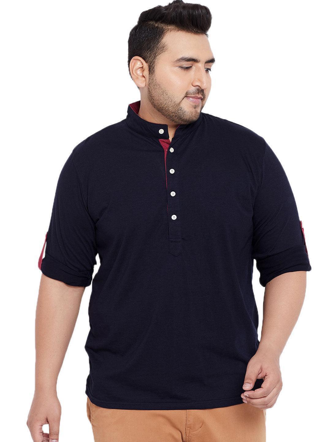Plus size man wearing navy blue mandarin collar shirt with button placket and rolled sleeves.