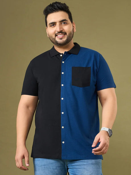Plus size man wearing a black and blue colorblock polo shirt with front pocket and jeans