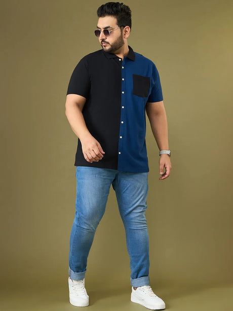 Plus size man in colorblock short sleeve shirt, blue jeans, and white sneakers