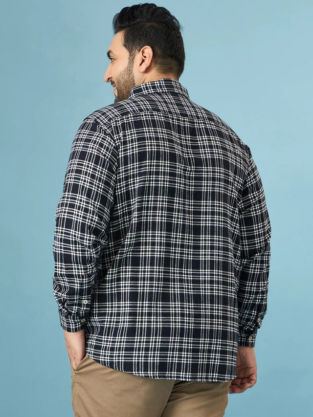 Back view of man in black and white checkered plus size shirt and beige pants
