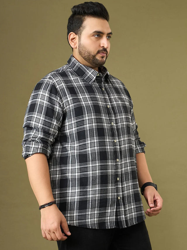 Plus size man wearing a black and white checkered shirt with rolled-up sleeves