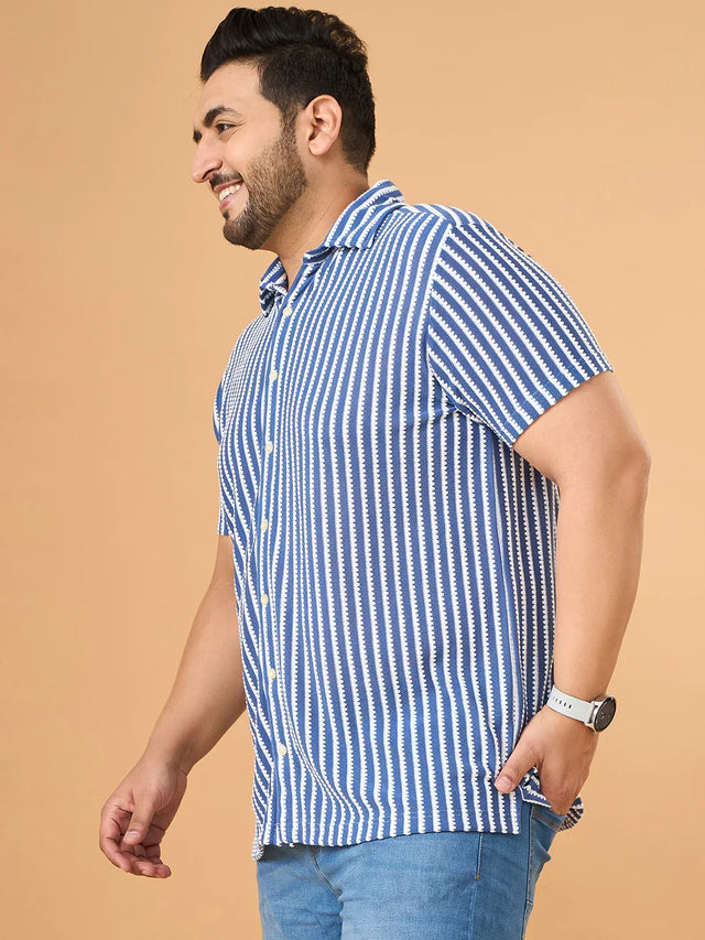 Plus size man wearing a blue and white striped short sleeve shirt and jeans