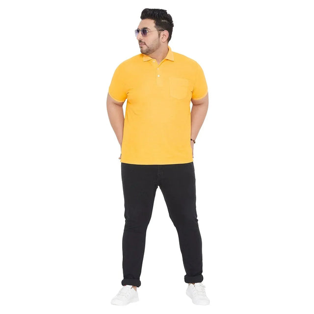 Plus size man wearing yellow polo t-shirt with pocket, black jeans, and white sneakers