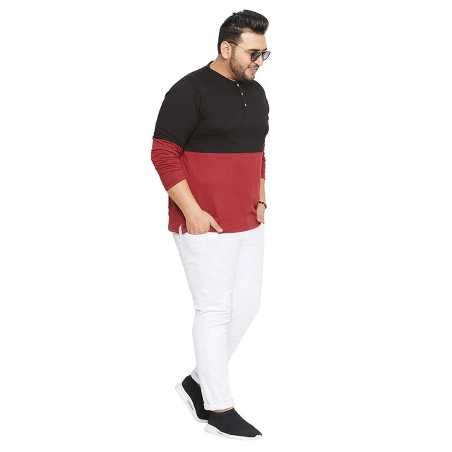 Plus size man in colorblock black and maroon Henley t-shirt and white jeans