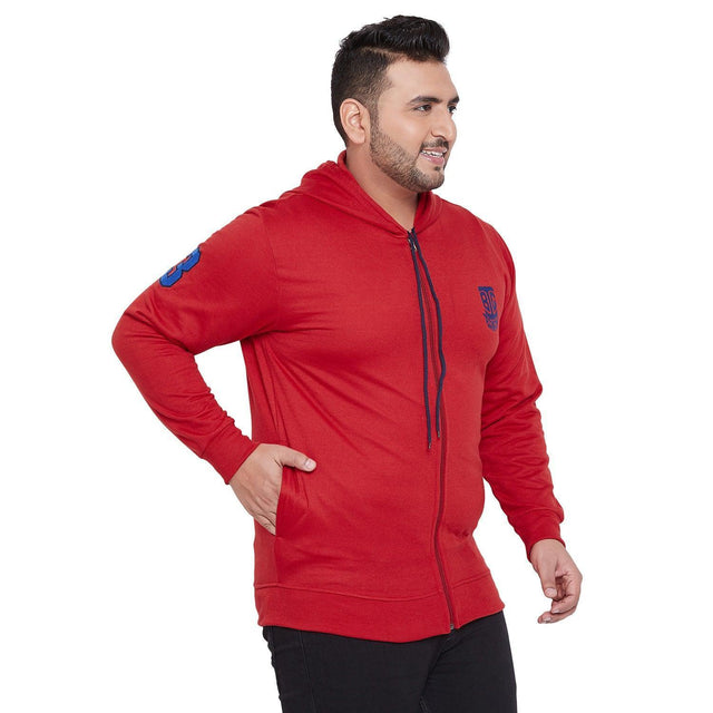 Plus size man in red zip-up hoodie with blue emblem, side view, white background.