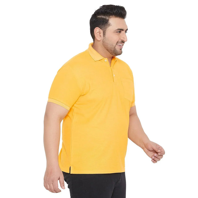 Plus size man in yellow polo t-shirt and black pants, side view on white background