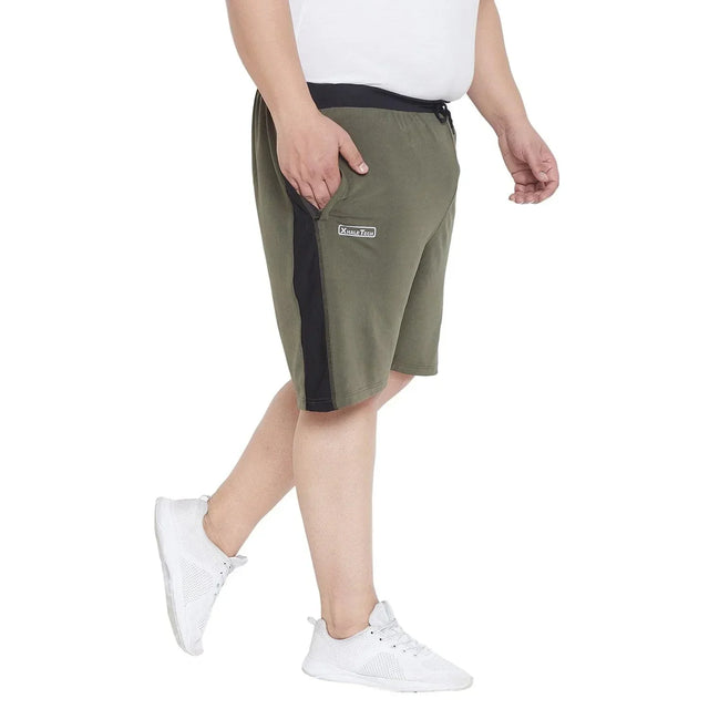Plus size man wearing olive green and black casual shorts with side pocket and white sneakers
