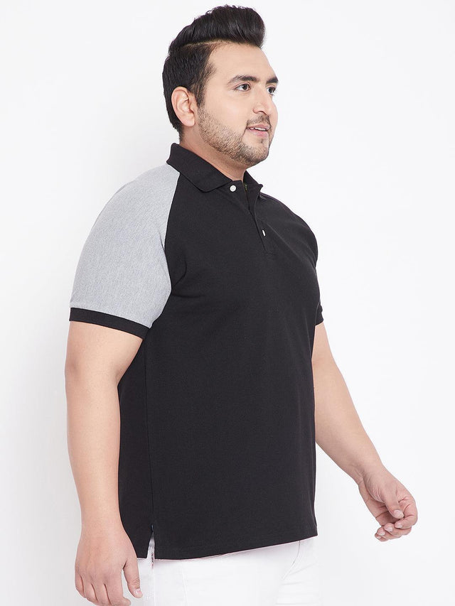 Plus size man wearing black polo t-shirt with grey sleeves, side view, white background