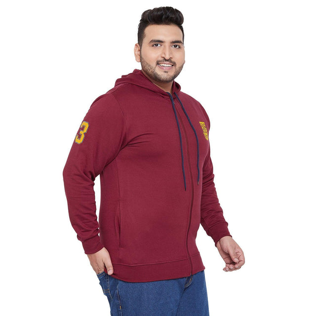 Plus size man in maroon zip-up hoodie with hood and yellow patch, casual wear