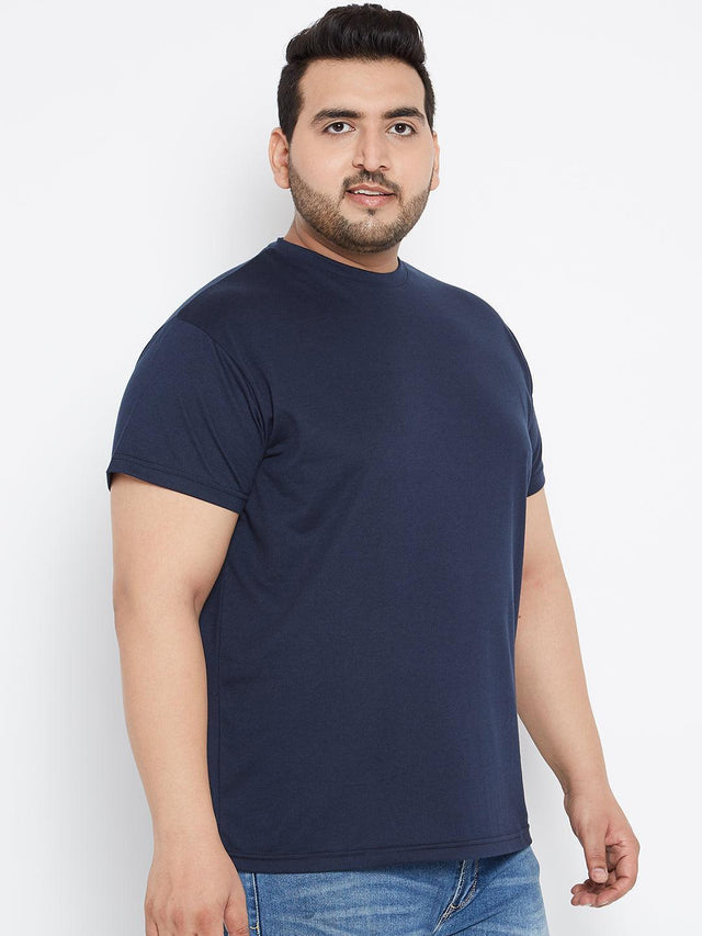 Plus size man wearing a navy blue t-shirt and blue jeans on a white background