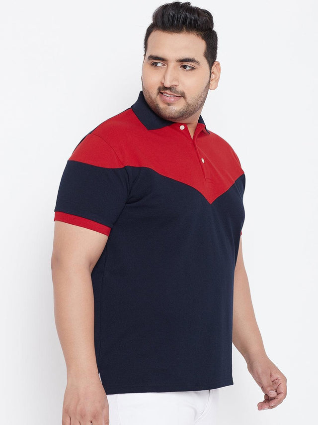Plus size man wearing a red and navy blue colorblock polo t-shirt with white pants