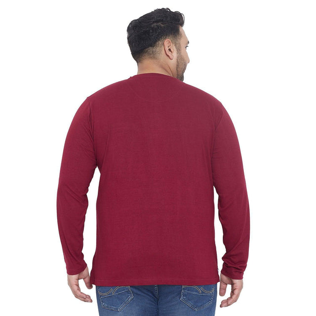 Back view of man in plus size maroon long sleeve t-shirt and blue jeans